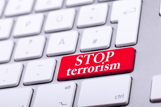 Keyboard with red button and stop terrorism word on it. Stop the war and abuse