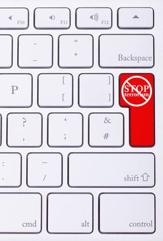 Red button on keyboard with stop terrorism word on it. Criminal attack
