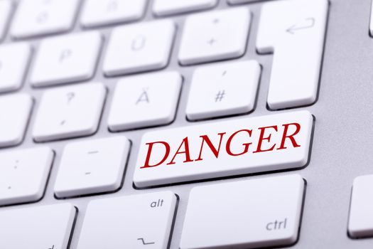 High end aluminium keyboard with DANGER word in red on it. Danger and alert