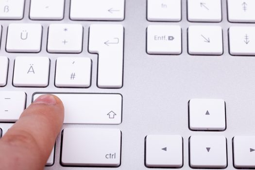 Finger pressing on keyboard key in close up