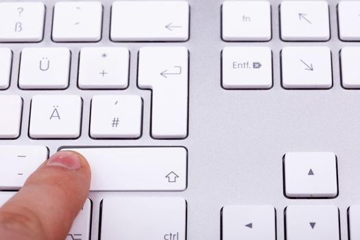 Finger pressing on keyboard key in close up