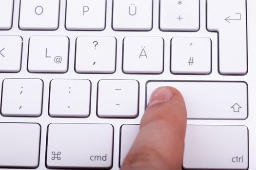 Finger pressing on keyboard key in close up