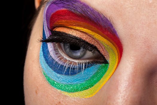 Eye in close up with artistic rainbow make up. Beauty image