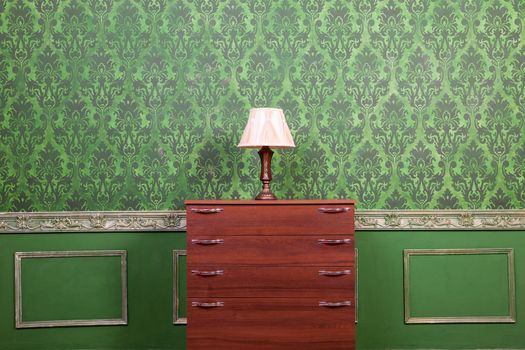 Vintage lamp on chimney on green retro pattern background. Rococo style