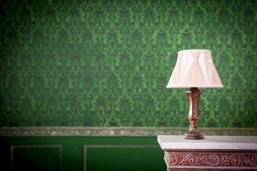 Vintage lamp on chimney on green retro pattern background. Rococo style