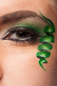 Close up of an eye with green artistic make up in studio photo