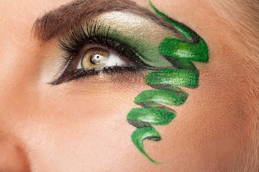 Eye with professional artistic green make up in studio photo