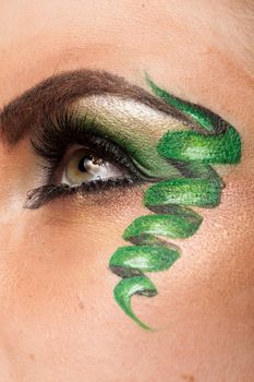 Close up of an eye with green artistic make up in studio photo