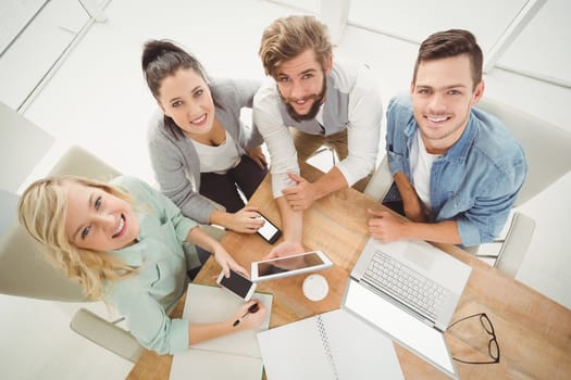 Overhead portrait of smiling business people while sitting at desk