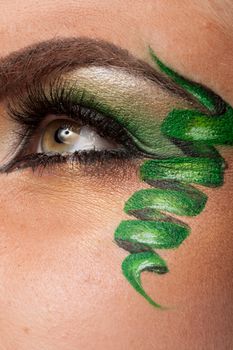 Close up of an eye with green artistic make up in studio photo