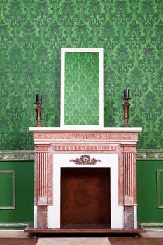 Old vintage mirrod in woden frame on chimney on green vintage pattern background
