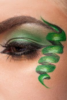 Close up of an eye with green artistic make up in studio photo