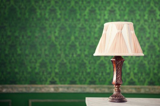 Vintage lamp on fireplace on retro pattern background. Retro vintage period. Rococ style. Luxury vintage interior