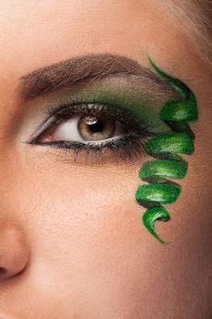 Close up of an eye with green artistic make up in studio photo