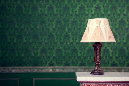 Vintage lamp on green pattern background on chimney with retro tonning