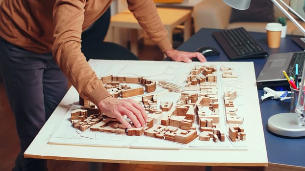 Male architect working on construction of a new city. Building models.