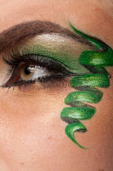 Close up of an eye with green artistic make up in studio photo