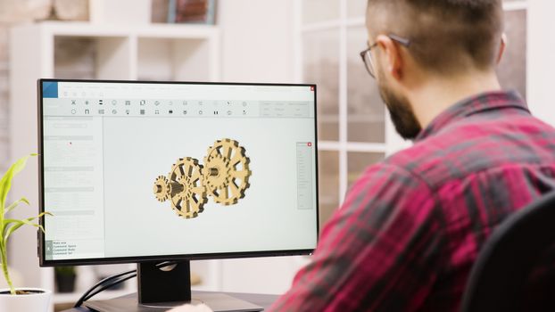 Male engineer working on a 3d design from home. Girlfriend in the background.