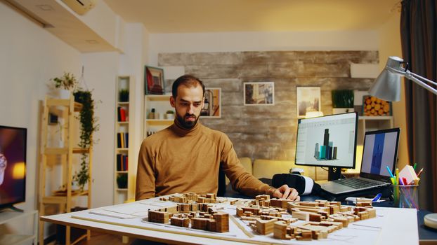 Young architect using augmented reality holograms for his building models.
