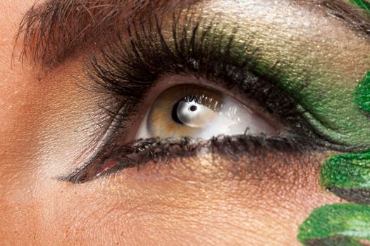 Close up of an eye with green artistic make up in studio photo
