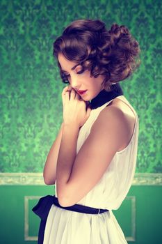 Gorgeous woman vintage toned image in retro room. Professional make up and hairstyle. Studio lighting
