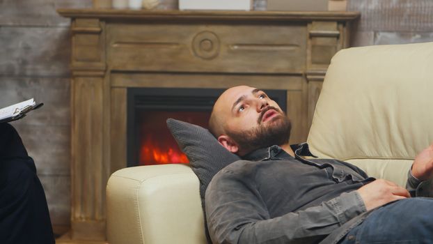 Close up of young man laying on couch at relationship counseling.