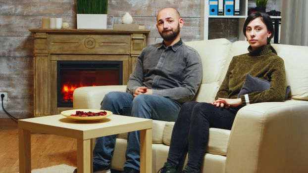 Nervous young couple sitting on couch at couple therapy.