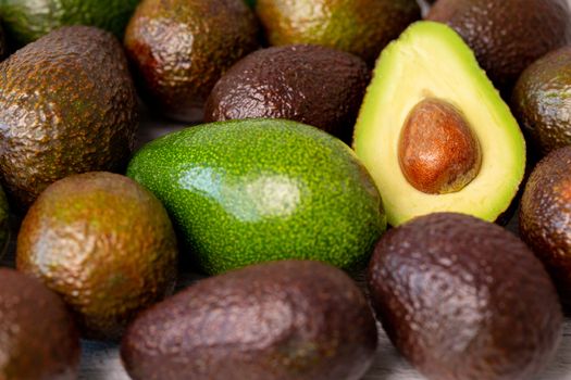 Cutted avocado fruit next to other one.
