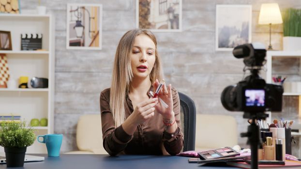Beautiful beauty influencer recording a vlog about make-up brush. Famous makeup artist.