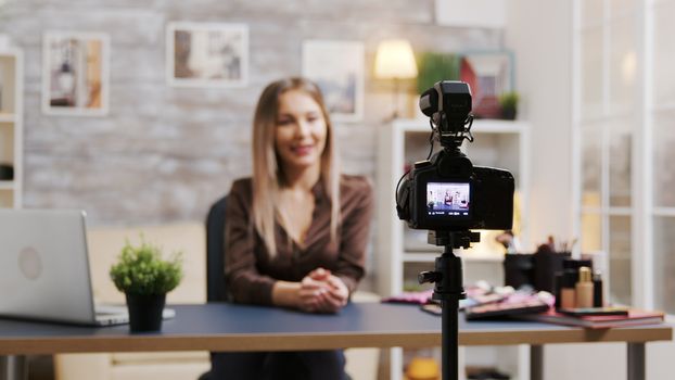 Beautiful beauty influencer recording a tutorial of how to use makeup. Attractive woman filming a vlog.