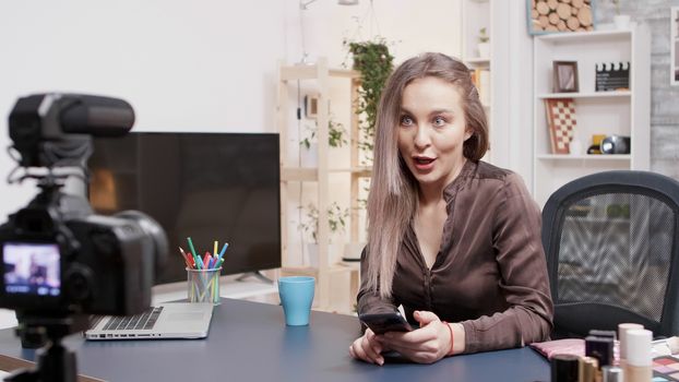 Beauty influencer laughing and smiling while reading questions from her followers in front of the camera