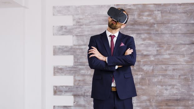 Real estate agent in business suit using virtual reality goggles in empty apartment.