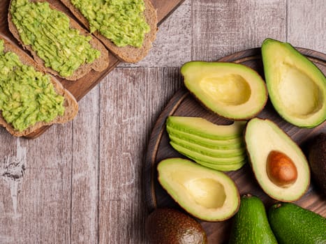Top view of sandwiches made with avocado on a wooden board