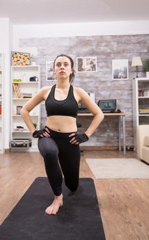 Young woman doing lunges exercise at home for a fit body.
