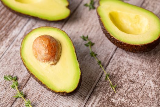 Avocado composition cutted in half on a wooden board.