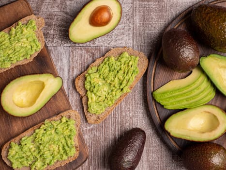 Top view of healthy sandwiches made with avocado on a wooden board