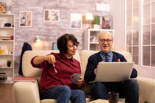 Elderly old couple using modern laptop to chat with their grandson. Grandmother and grandfather using modern technology
