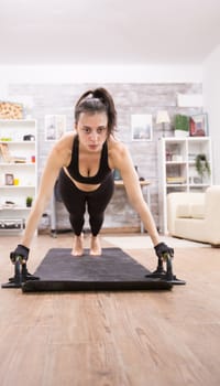Attractive young woman doing push ups to have a fit body. Healthy lifestyle.