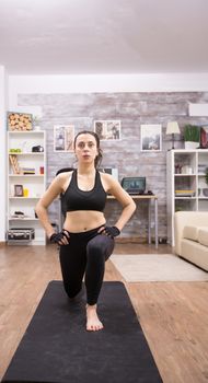 Young woman doing lunges at home for a healthy body. Fitness training.