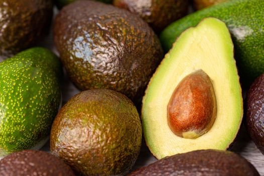 Cutted avocado fruit next to other one.