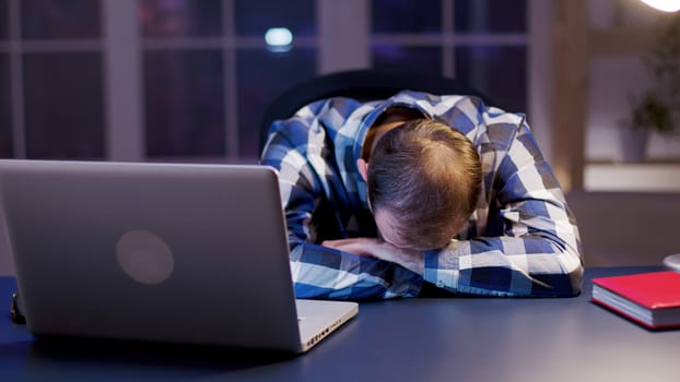 Caucasian businessman sleeping with his head on the office. Overworked entrepreneur.