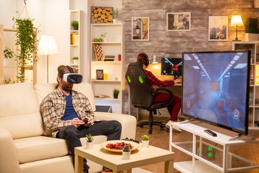 Man gamer using a VR headset to play video games in the living room late at night