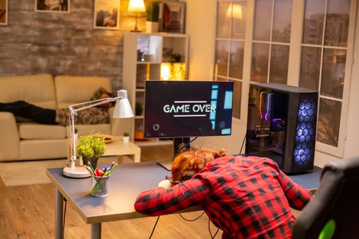 Gamer woman losing at a video game playing late at night in the living room.