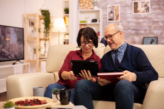 Beautiful old couple using a digital tablet to chat with their family. Elderly people using modern technology