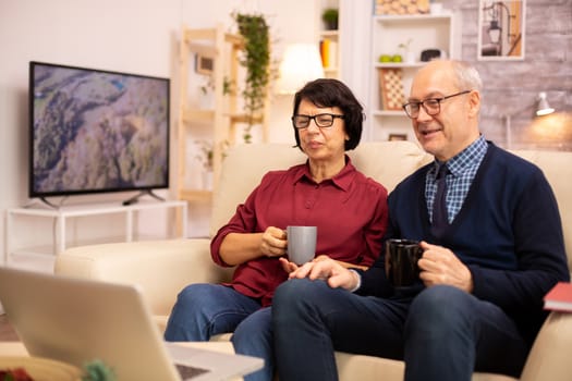 Elderly old couple using modern laptop to chat with their grandson. Grandmother and grandfather using modern technology