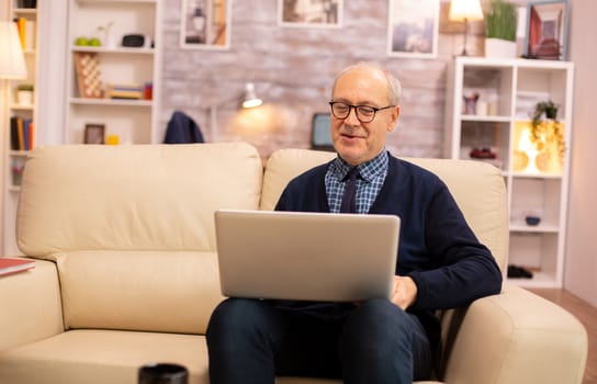 Elderly old couple using modern laptop to chat with their grandson. Grandmother and grandfather using modern technology