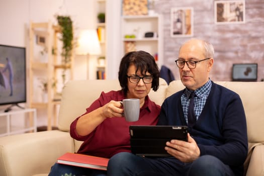 Beautiful old couple using a digital tablet to chat with their family. Elderly people using modern technology