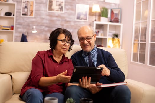 Beautiful old couple using a digital tablet to chat with their family. Elderly people using modern technology