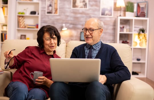 Elderly old couple using modern laptop to chat with their grandson. Grandmother and grandfather using modern technology