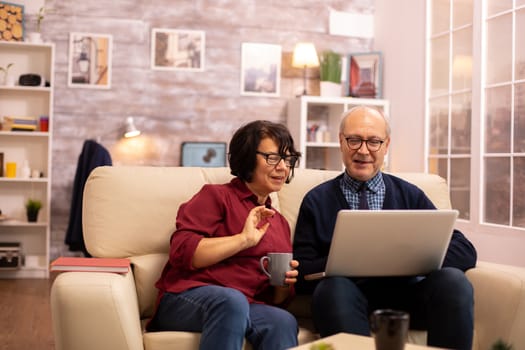 Elderly old couple using modern laptop to chat with their grandson. Grandmother and grandfather using modern technology